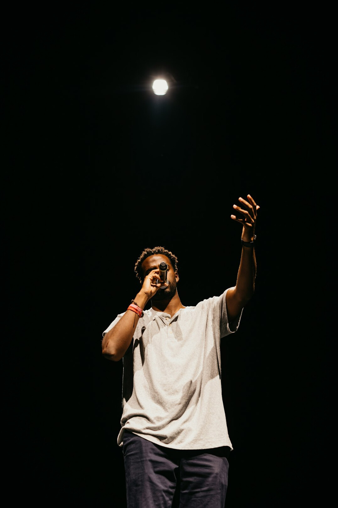 man singing on stage with microphone