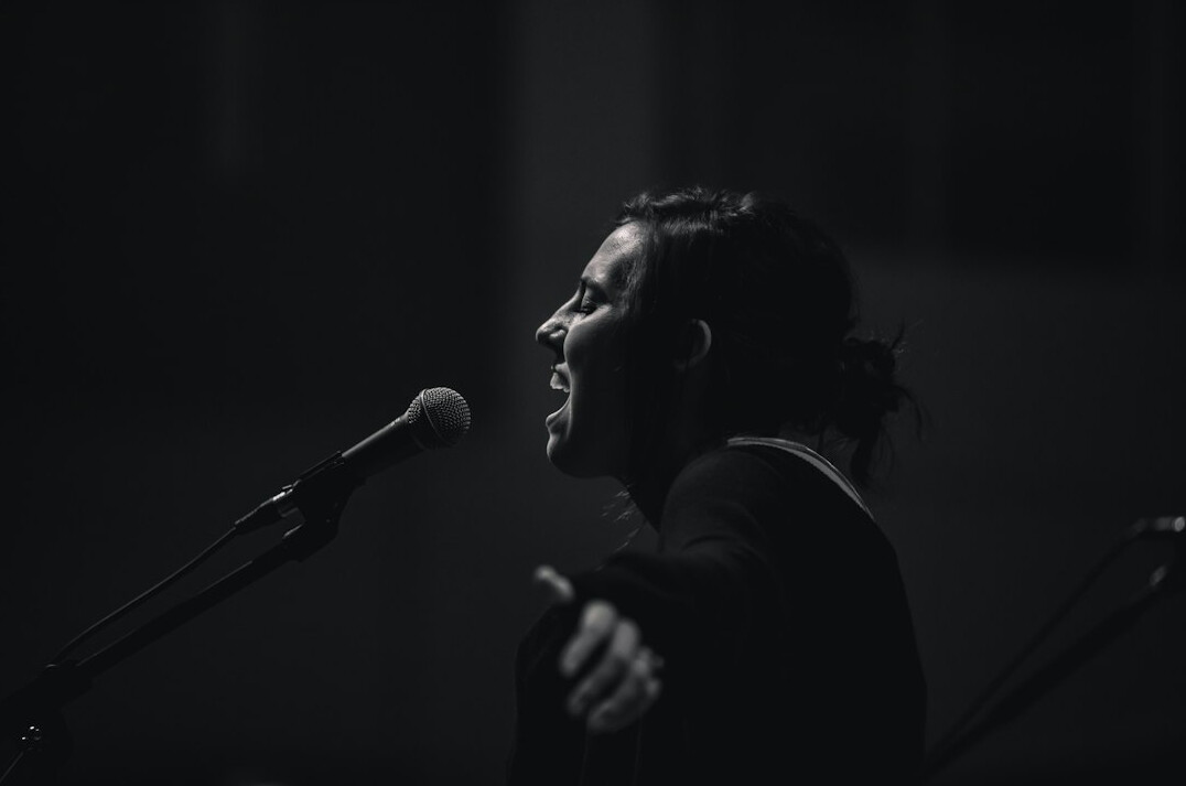man singing on stage with microphone